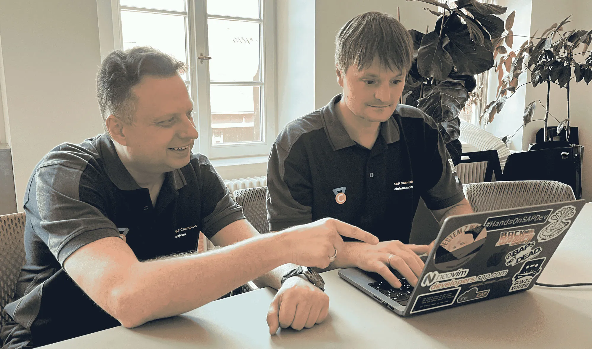 Damir Majer und Christian Drumm arbeiten zu zweit an einem Laptop